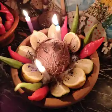 Oferenda com velas acesas firmada no terreiro